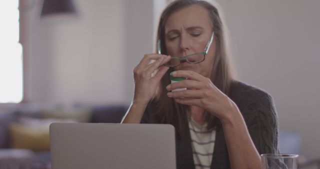 Elderly Woman Drinking from Cup While Using Laptop at Home - Download Free Stock Images Pikwizard.com