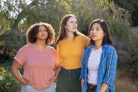 Diverse Female Friends Standing Thoughtfully in Sunny Garden