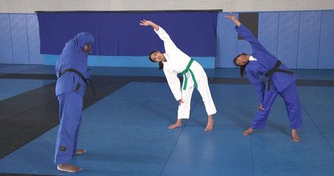 Martial arts students stretching in training hall
