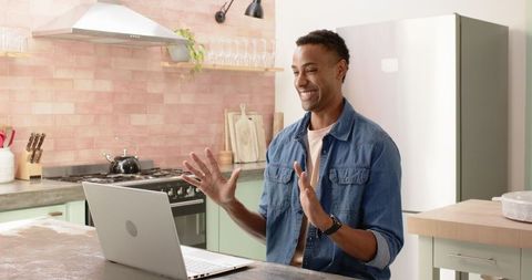 Smiling man on video call in cozy kitchen environment