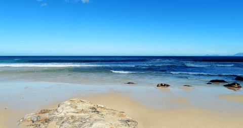 Transparent Coastal Serenity with Clear Skies and Gentle Waves