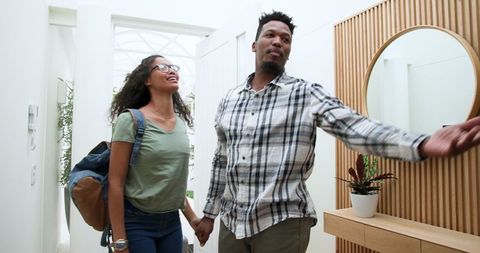 Couple Arriving for Vacation Holding Hands Smiling