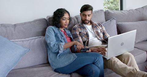 Young Couple Shopping Online at Home on Sofa