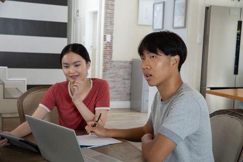 Young friends collaboratively studying with modern tech