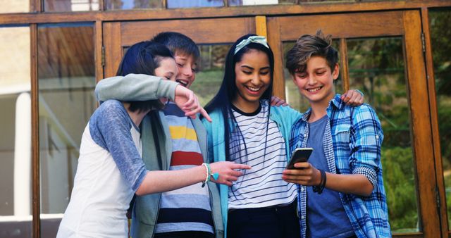 Group of Teenagers Laughing and Looking at Phone Outdoors - Download Free Stock Images Pikwizard.com