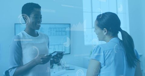 Diverse women collaborating with digital technology in office