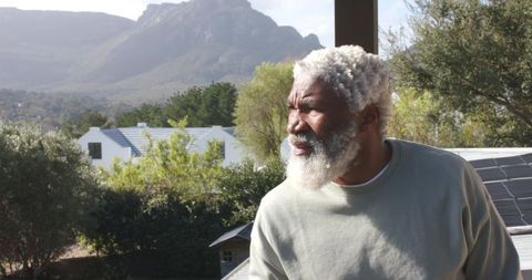 Senior Man Enjoying Outdoor Scenic View from Modern Eco-friendly Balcony