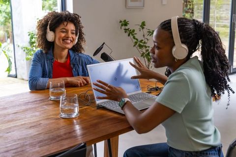 African american women recording podcast at home, hosting interview with laptop and microphone