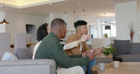 Diverse friends discussing on sofa in modern open-plan living room during casual conversation