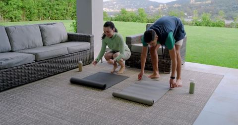 Couple Preparing for Outdoor Yoga Session on Modern Terrace