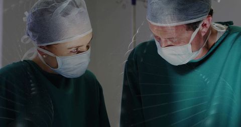 Surgeons collaborating in operating room performing delicate surgery wearing masks and gowns
