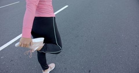 Fitness Enthusiast Stretching on Open Road Preparing for Workout