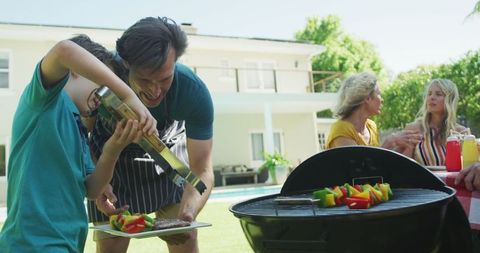 Family Enjoying BBQ Gathering in Backyard