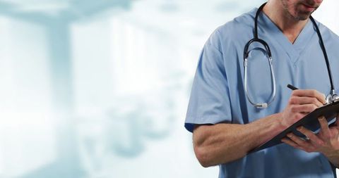 Medical professional writing notes with stethoscope