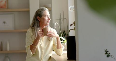 Serene Mature Woman Sipping Coffee in Natural Light
