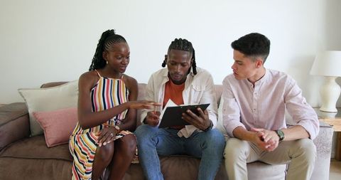 Friends discussing book on couch in engaging conversation