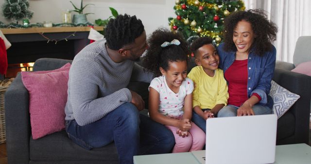 Smiling african american family having image call and gesturing, christmas decorations in background. family christmas time and festivity together at home.