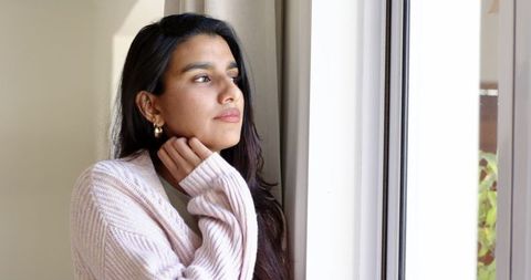 Woman Gazing Out Window in Serene Home Setting