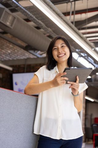 Asian Businesswoman Smiling in Modern Open-Plan Office
