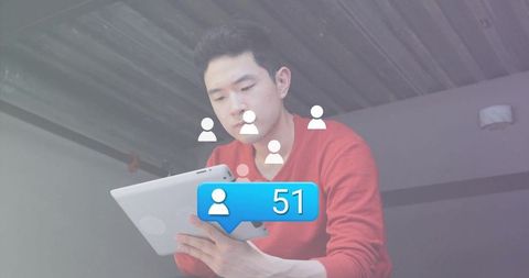 Young Man Engaged with Tablet Displaying Social Media Notifications