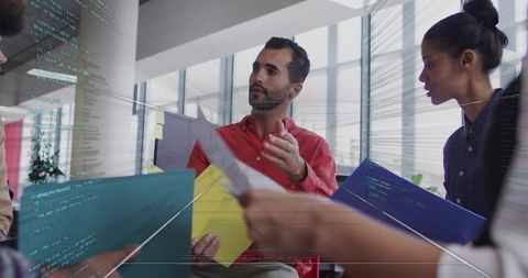 Colleagues Engaging in Strategic Discussion Surrounded by Code Interface