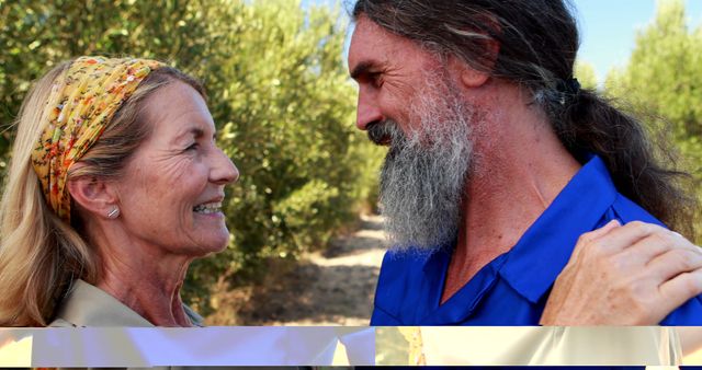 A middle-aged Caucasian woman and man share a joyful moment outdoors, with copy space. Their warm interaction suggests a close relationship or a heartfelt reunion.