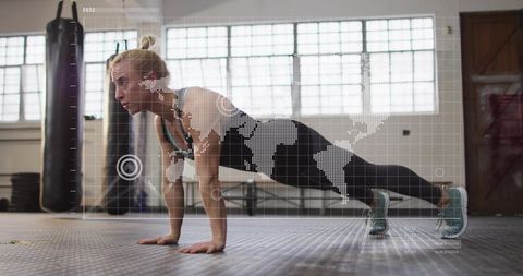 Focused woman holding plank with digital world-map hud overlay in sunlit industrial gym core trainin