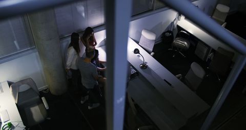 Executives Collaborating on Late-Night Project in Modern Office