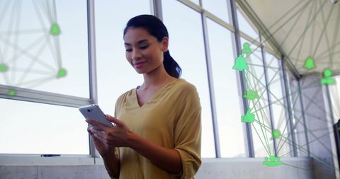 Asian Woman Engaging with Smartphone in Modern Office