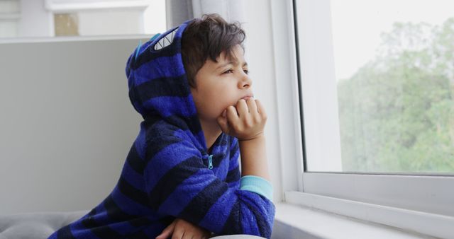 Thoughtful Child in Striped Pajamas Staring Out Window - Download Free Stock Images Pikwizard.com