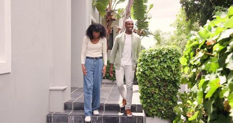 Happy Couple Walking Down Steps on Sunny Day
