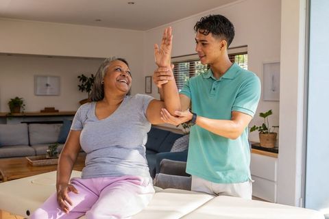 Senior African American Woman Receiving Arm Therapy at Home