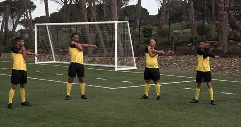 Soccer players stretching on field preparing for training
