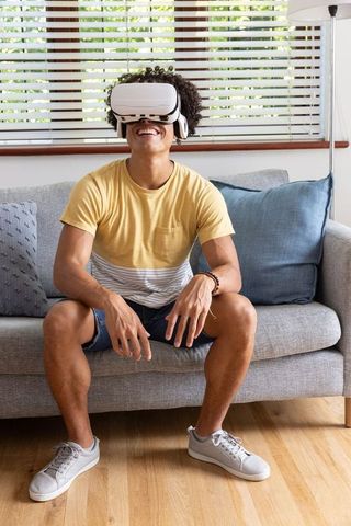 Engaged person with virtual reality headset in modern living room