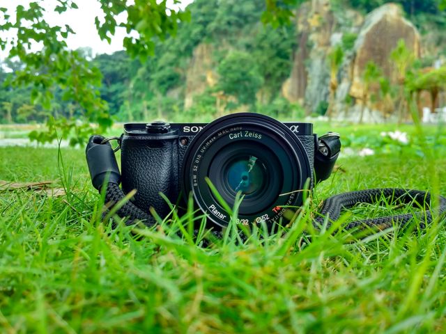 Black Sony Dslr Camera on Green Grass in Front of Brown and Green Mountain - Download Free Stock Photos Pikwizard.com