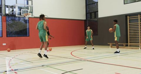 Team of Male Basketball Players Practicing on Indoor Court