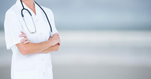 Nurse standing with arms crossed and stethoscope around neck on blurred blue background. Suitable for healthcare and medical-related promotions, advertisements, websites, brochures, and articles highlighting nursing staff, hospital services, and professional healthcare. Ideal for conveying confidence, professionalism, and trust in medical care.