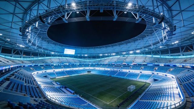 Futuristic empty soccer stadium at night with illuminated ring roof and blue seating