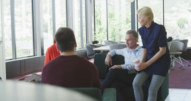 Office Colleagues Engaging in Discussion Near Large Windows - Download Free Stock Images Pikwizard.com