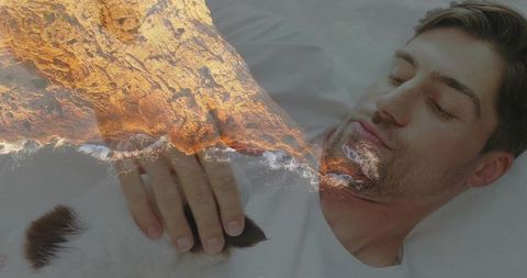 Reclining man petting cat with rocky shoreline overlay