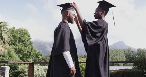 Graduates celebrating outdoors with mountainous background