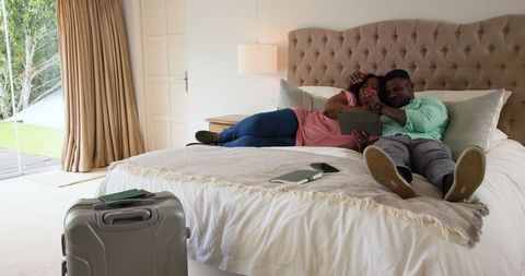 Couple Relaxing on Bed Watching Smartphone Leisurely