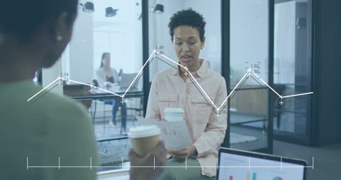 Women Analyzing Data with Digital Graph Overlay in Modern Office