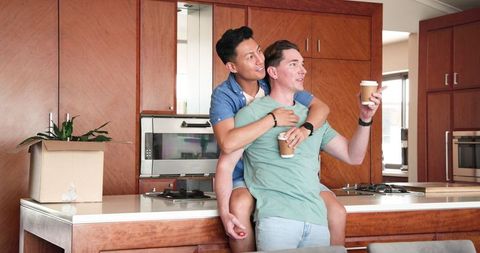 Diverse Male Couple Enjoying Coffee in Warm Embrace at Home