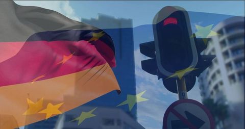 German flag waving with eu stars overlay on city intersection traffic light showing red