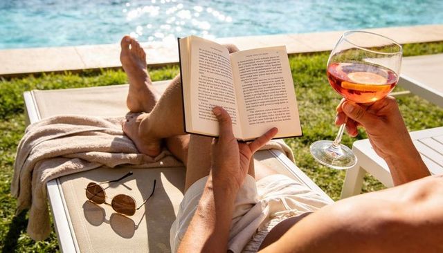 Relaxing poolside reading with rosé on sunlit lounge chair, summer leisure and vacation vibes