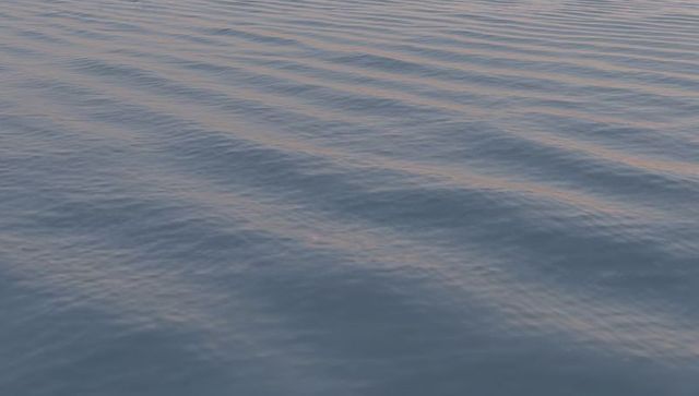 Shimmering Ocean Surface with Soft Diagonal Ripples and Warm Sunset Reflections