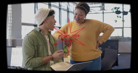Young coworkers collaborating with laptop in bright open-plan office discussing system core