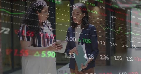 Businesswomen Analyzing Stock Market Data on Tablet and Folder
