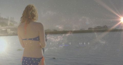 Woman in Polka-Dot Bikini Overlooking Tranquil Lake with Lens Flare